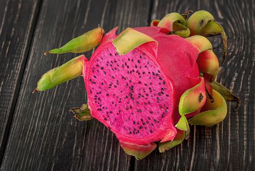 Half dragon fruit on a wooden planks blurred background