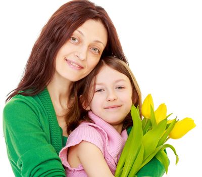 Happy mother gives her daughter a bouquet of yellow tulips.Isolated on white background.