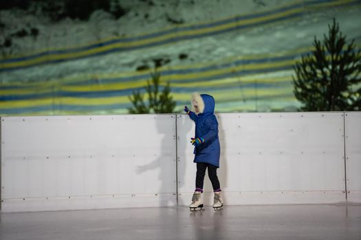 Little girl learning to skate at the rink.