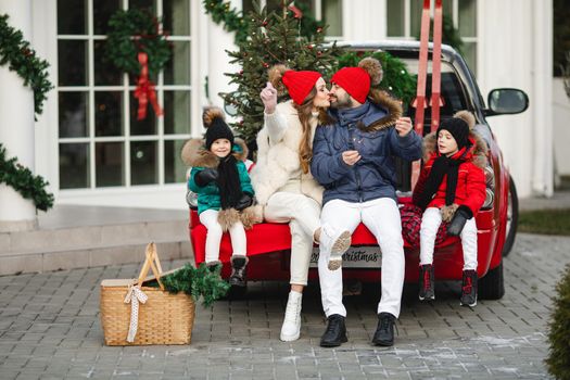 caucasian mum, dad and their beautiful children spend christmas time together