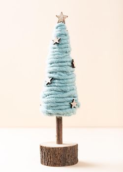 Festive composirion with wooden and felting wool christmas tree over beige background. Copy space, winter holidays greeting card