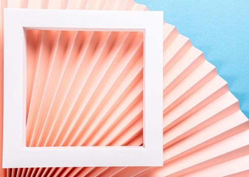 Colorful abstract background with pink paper fans and white frame. Trend Concept. Top view, close up, copy space