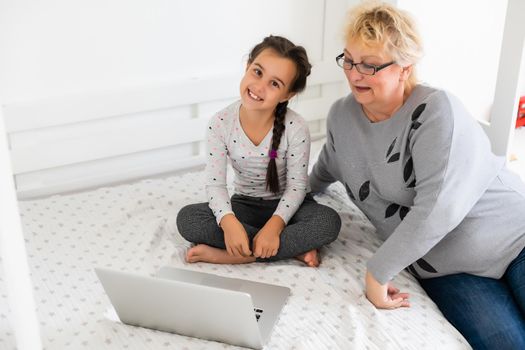 Helpful granny. Helpful loving granny assisting her cute granddaughter making homework