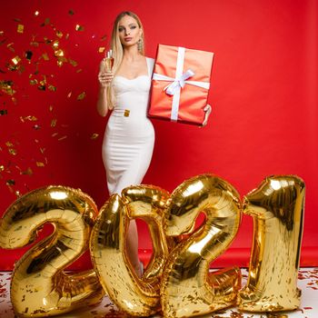 Stock photo of posh blonde woman in white cocktail dress holding glass of champagne