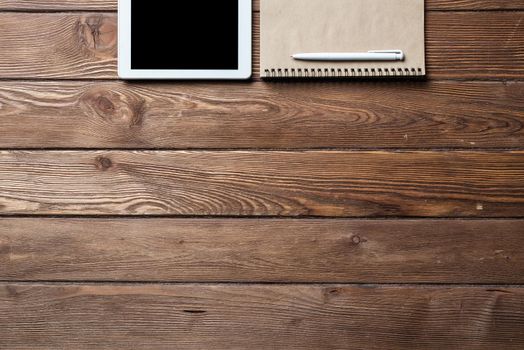 Top view of well organized home office workplace. Spiral notepad, pen and tablet computer on white surface. Education, creativity and working concept. Minimalist business design with copy space.