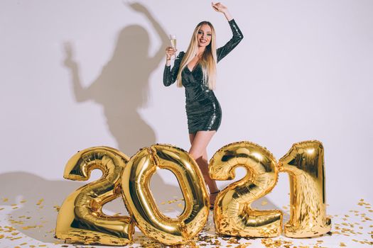 Stock photo of stunning blonde model in cocktail dress posing with raised arm