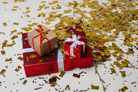 three boxes with a presents in a beautiful pack with a lot of gold confetti around them