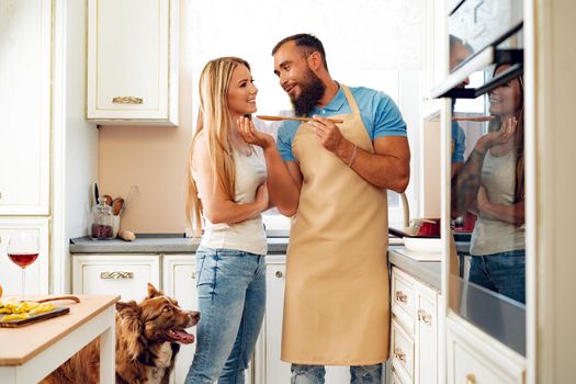 Young loving couple cooking together in kitchen at home