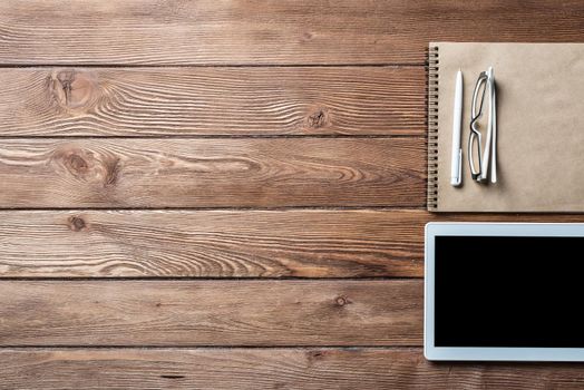 Top view of well organized home office workplace. Spiral notepad, pen and tablet computer on white surface. Education, creativity and working concept. Minimalist business design with copy space.