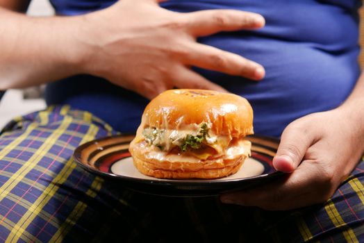 hand holding beef burger on table close up .