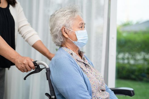 Help Asian senior or elderly old lady woman sitting on wheelchair and wearing a face mask for protect safety infection Covid-19 Coronavirus.