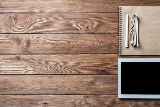 Top view of well organized home office workplace. Spiral notepad, pen and tablet computer on white surface. Education, creativity and working concept. Minimalist business design with copy space.