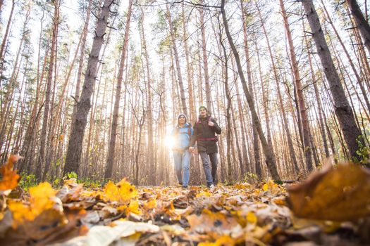 People, camping trip and nature concept - Low-angle shot of tourist couple hiking in forest.