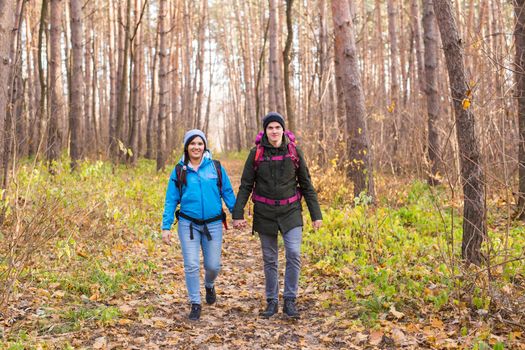 People, hike, tourism and nature concept - Couple tourist hiking in autumn forest.