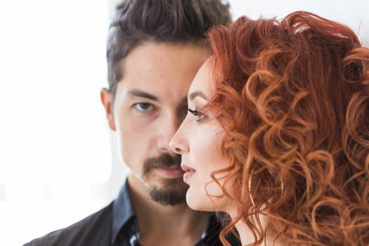 People and love concept - Head shot portrait of couple with serious faces over white wall.