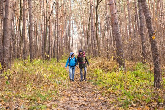 People, hike, tourism and nature concept - Couple tourist hiking in autumn forest.