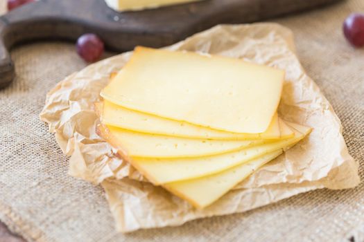 Close up of sliced cheese on rustic background.