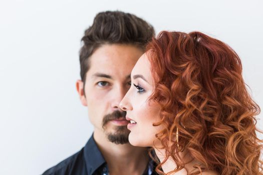 People and love concept - Head shot portrait of couple with serious faces over white wall.