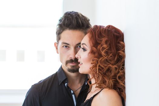 People and love concept - Head shot portrait of couple with serious faces over white wall.