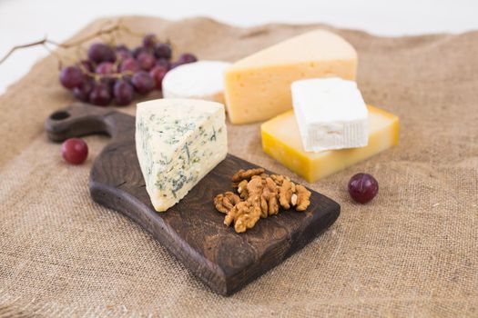 Fresh products. Cheese, brie, Camembert, grapes and nuts on rustic table