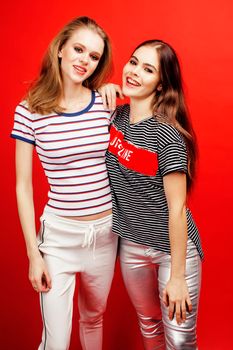 two best friends teenage girls together having fun, posing emotional on red background, besties happy smiling, lifestyle people concept close up