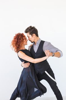 Social dance, bachata, kizomba, tango, people concept - Young couple dancing over white background