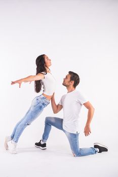 Young couple dancing social dance bachata, merengue, salsa, kizomba. Two elegance pose on white room