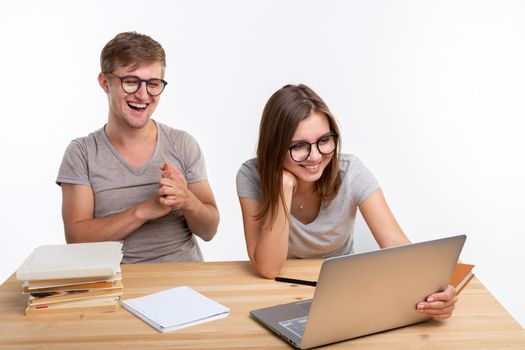 People and education concept - Two laughing students sitting at a table.