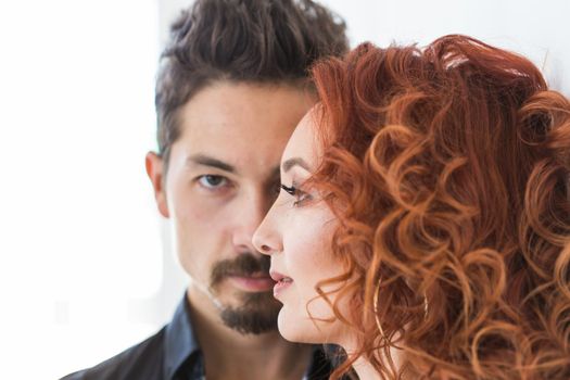 People and love concept - Head shot portrait of couple with serious faces over white wall.