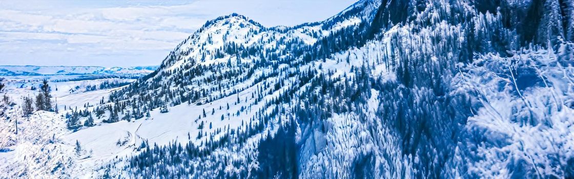 Winter wonderland and magical Christmas landscape. Snowy mountains and forest covered with snow as holiday background.