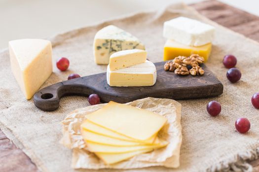 Fresh products. Cheese, brie, Camembert, grapes and nuts on rustic table