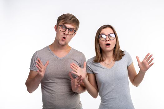 People and education concept - Two young student with thoughtful faces over white background.