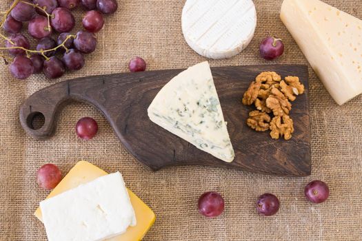 Fresh products. Cheese, brie, Camembert, grapes and nuts on rustic table