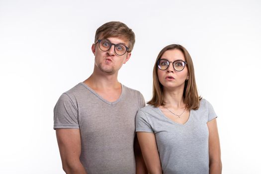 People and education concept - Two young student with thoughtful faces over white background.