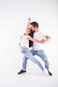 Young couple dancing social latin dance bachata, merengue, salsa. Two elegance pose on white background.