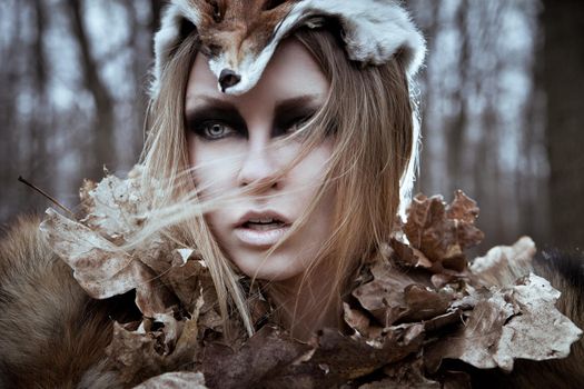 Romantic wild beauty tribal woman in fox costume in wild forest. Vintage styled