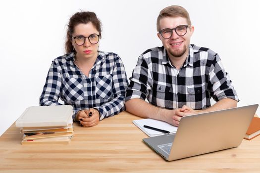People and education concept - Two students dressed in plaid shirt sitting at a table.