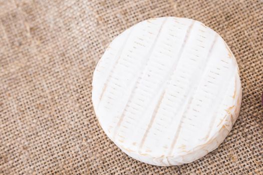 Camembert cheese. Fresh Brie cheese on a rustic background.