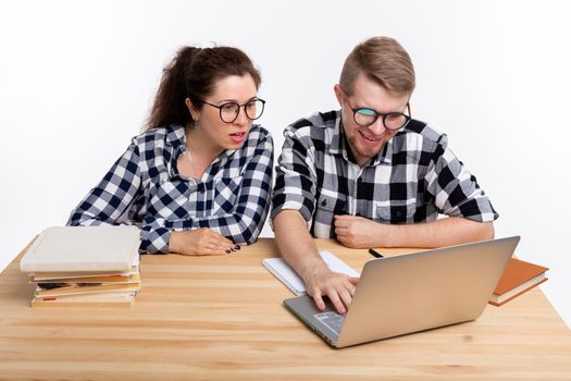 People and education concept - Two students dressed in plaid shirt sitting at a table.