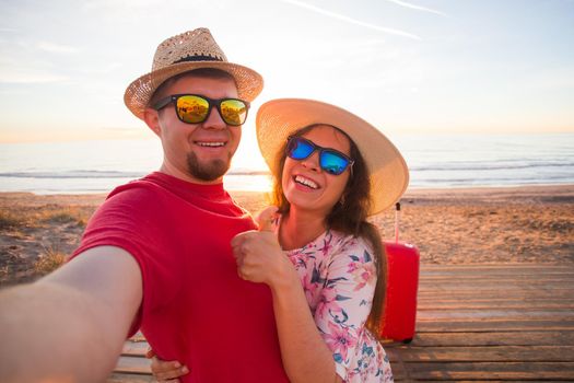 Travel and holidays concept - Happy young couple in love takes selfie portrait on the beach.