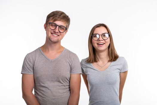 People and education concept - Two young student with thoughtful faces over white background.