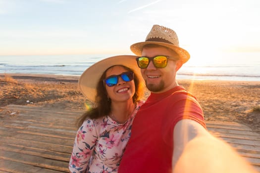 Travel, summer and holiday concept - Lovely couple taking selfie on a beach.