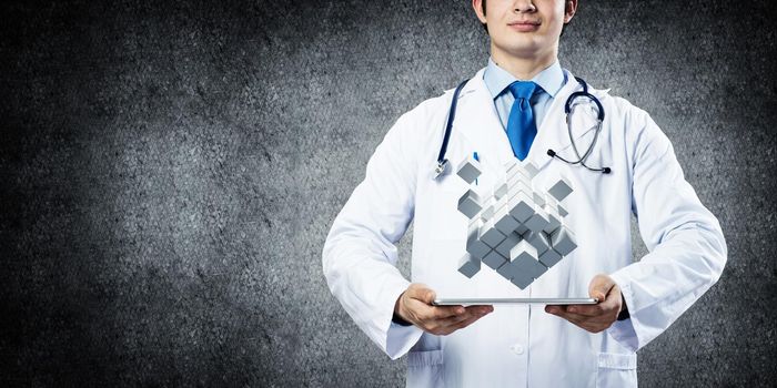 Confident and professional doctor in medical uniform presenting set of multiple cubes above tablet in his hands.