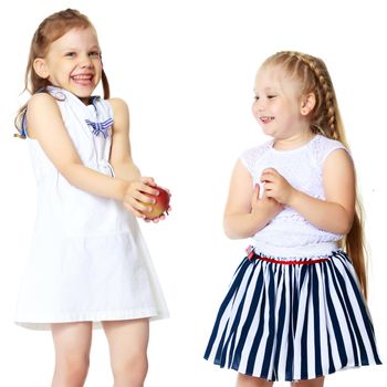 Two cute little girls with apples, in the studio on a white background. Concept of happy childhood, healthy eating. Isolated.