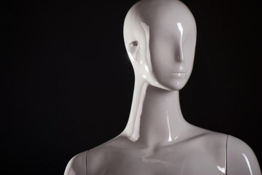 Head of female fashion mannequin against a black background