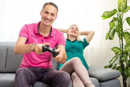 Couple playing video games at home