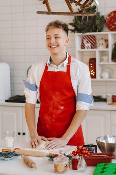 A male chef prepares dough in the Christmas kitchen before the New year.