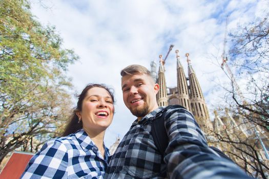 BARCELONA, SPAIN - FEBRUARY 6, 2018: Happy tourists photographing in front of the famous Sagrada Familia roman catholic church in Barcelona, architect Antoni Gaudi.