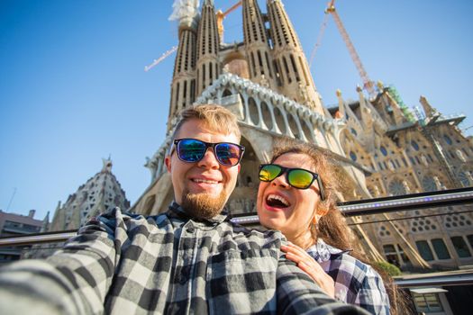 BARCELONA, SPAIN - FEBRUARY 7, 2018: Happy tourists photographing in front of the famous Sagrada Familia roman catholic church in Barcelona, architect Antoni Gaudi.