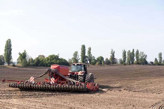 The tractor harvester working on the field